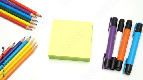 Colorful school and office supplies are neatly arranged on a crisp white background.