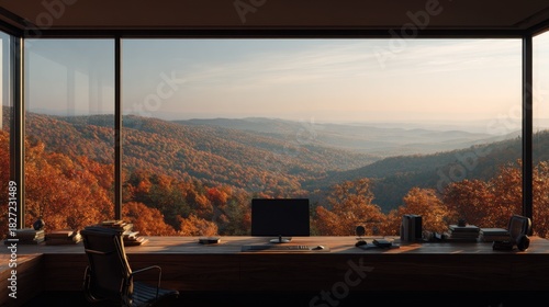 Modern office workspace with large windows overlooking autumn mountain landscape. Wooden desk with computer.
