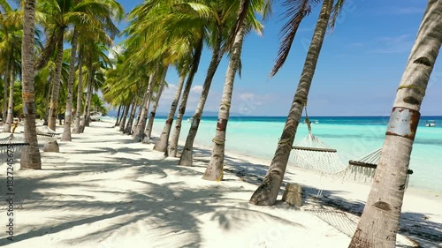 Beautiful tropical island with sand beach and hammock. Panglao, Philippines. Seascape with beautiful beach and palm trees.