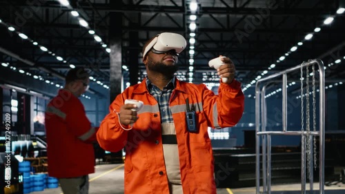 Black engineer wearing VR glasses interacting with a simulation system to analyze manufacturing process improvements. Steel machinery and industrial equipment for plant activity. Camera B.