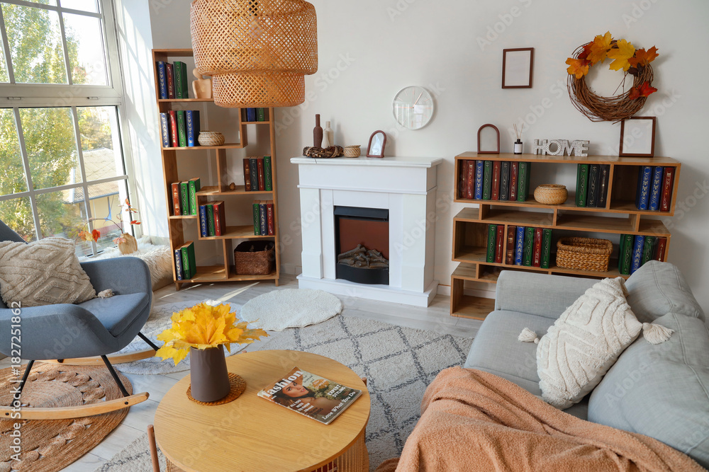 Fototapeta premium Interior of living room with autumn leaves, sofa and bookshelves