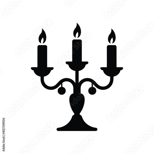 Black silhouette of a three armed candelabra with lit candles