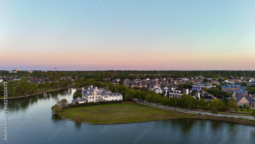 Fototapeta premium Aerial view of large mansion houses in affluent neighborhood by Woodlands lake, Houston, Texas, expensive suburban homes surrounding by lush green trees, USA