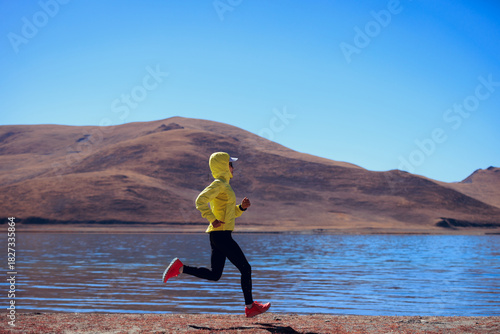 Ultra marathon runner running at winter high altitude lakeside, Tibet