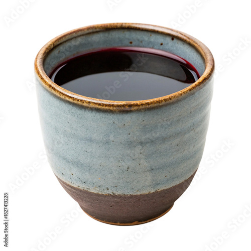 Rustic ceramic cup filled with dark red liquid, perfect for sipping herbal tea or rich berry juice, inviting a moment of cozy relaxation and mindful enjoyment