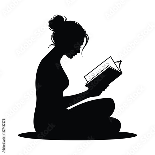 Silhouette of a woman reading a book cross legged