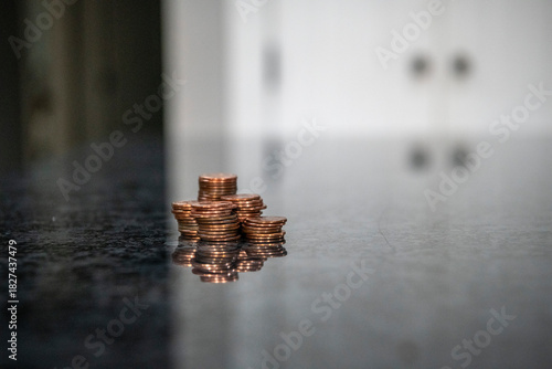 фотографія A stack of coins on a marble counter represents the demise of the penny due to the Treasury Department, which has stopped minting pennies