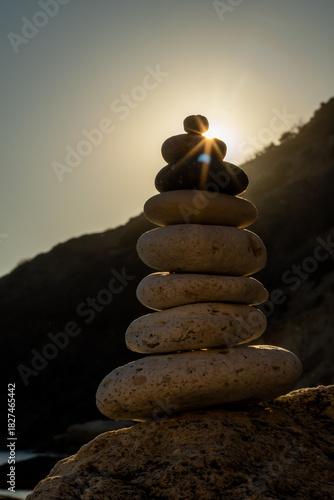 Photography Stones balance sunset stack cairn representing zen tranquility and spirituality with bright golden sun rays