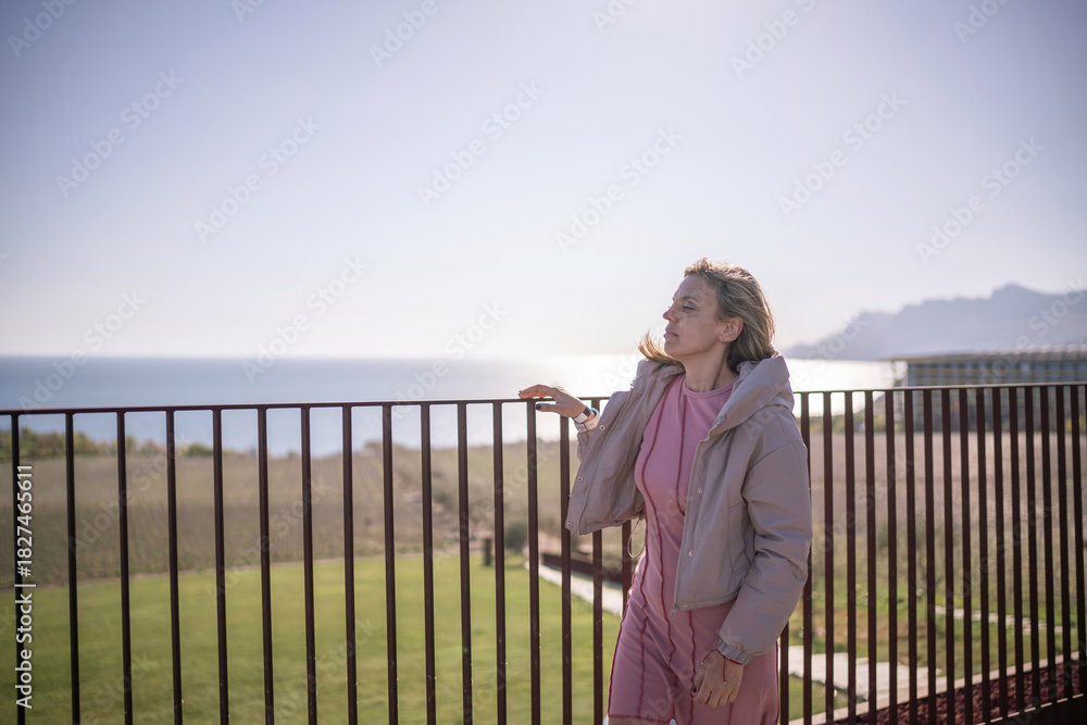 Fototapeta premium Woman vacation balcony railing watching sunrise over sea mountain landscape