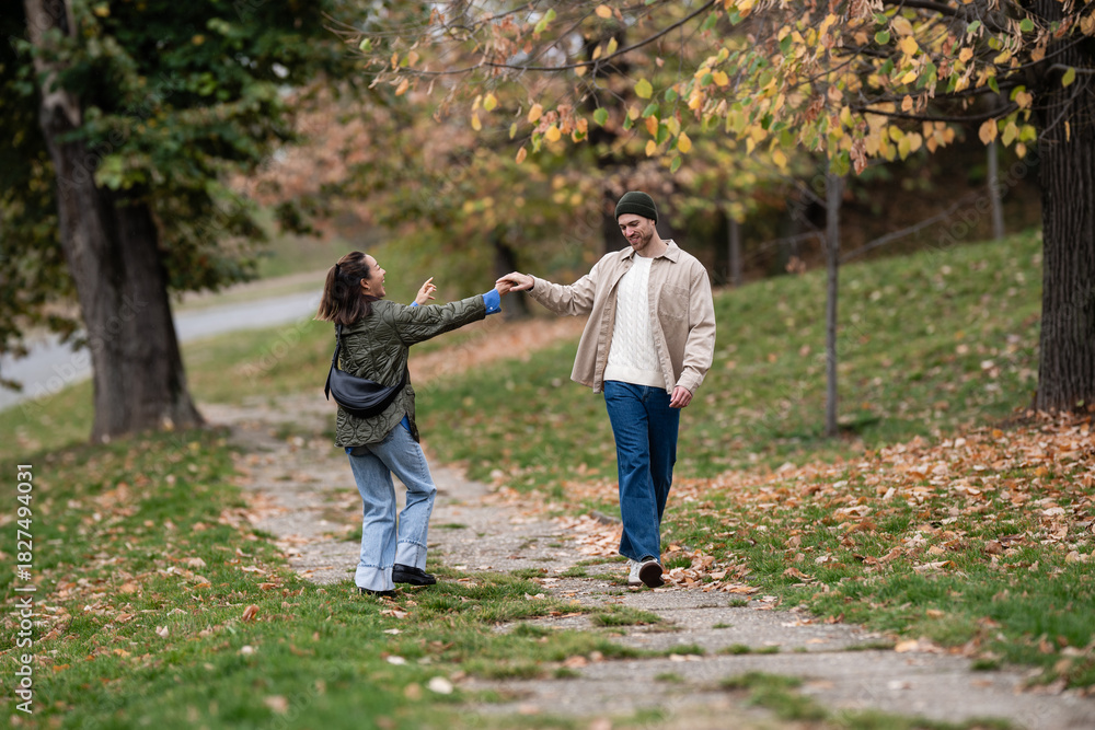 Fototapeta premium Couple walking and holding hands in autumn park