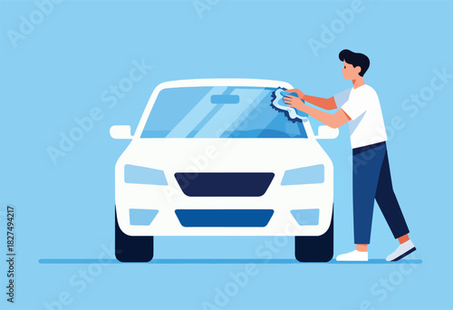A man washes a white car's windshield with a cloth, minimalist blue background