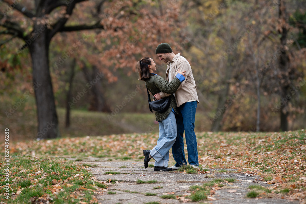 Fototapeta premium Loving couple embracing in autumn park pathway