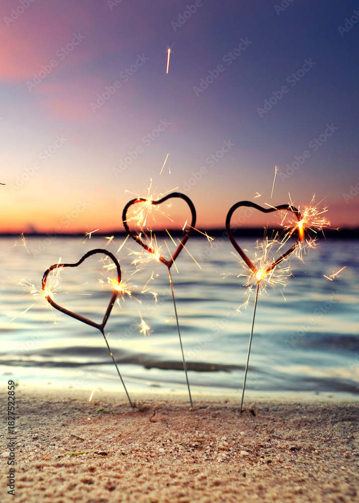 Obraz premium burning sparklers at the beach for happy new year 