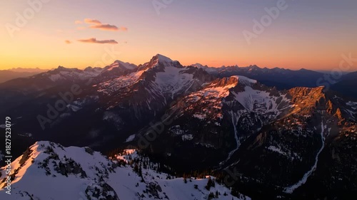 Sunrise panorama view over snowy mountain peaks and dramatic clouds
