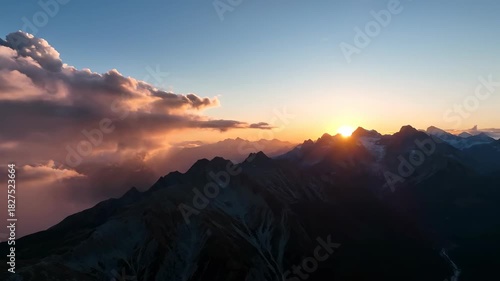 Golden sunlight illuminates the mountain landscape at sunrise and sunset, painting the sky with beautiful orange clouds and capturing the beauty of nature's view