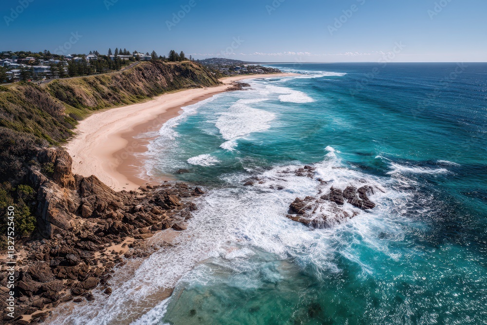 Obraz premium Bird's-eye coastal panorama over Nobbys Beach at Newcastle, Australia, sunlit shoreline, blue ocean and rocky promontory