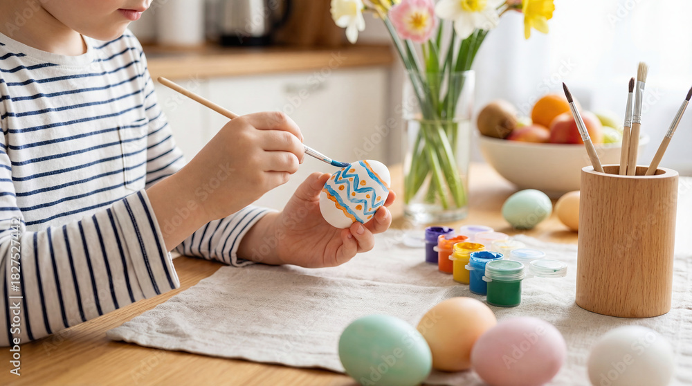 Fototapeta premium Child decorating colorful Easter eggs at home