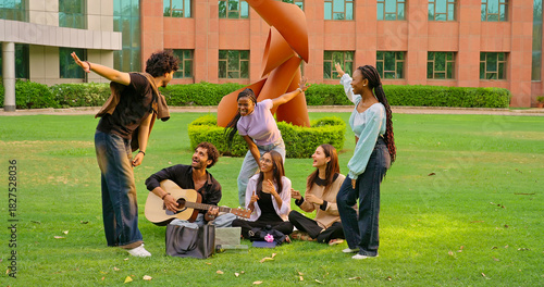 Fototapeta Indian young adult gen z male man hold guitar play new music lady woman sing song have fun joy