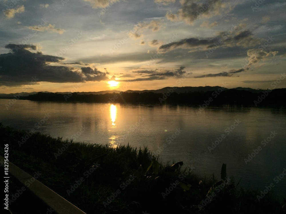 Obraz premium Riverside Landscape with Mountains during Sunset