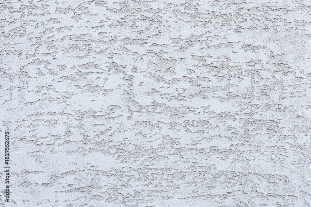 Obraz premium A textured white wall with subtle patterns and variations in tone. The surface appears rough and uneven, creating an interesting visual effect.
