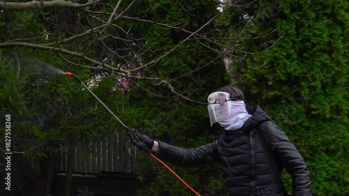 Winterizing plants. A woman treats plants for insects before winter.