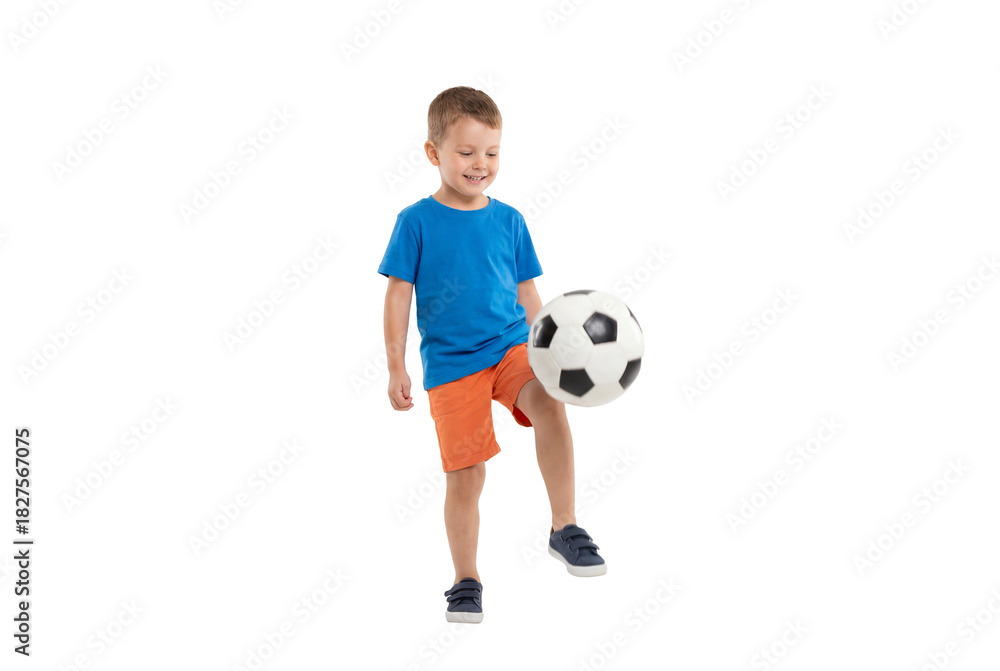 Fototapeta premium Young boy juggling a soccer ball on isolated background, active childhood play and beginner football skills for youth sports training and physical education concepts