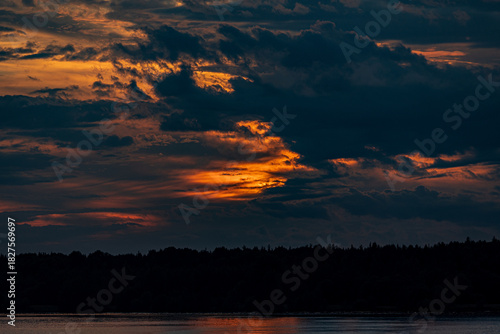 Beautiful sunset in the clouds over the river
