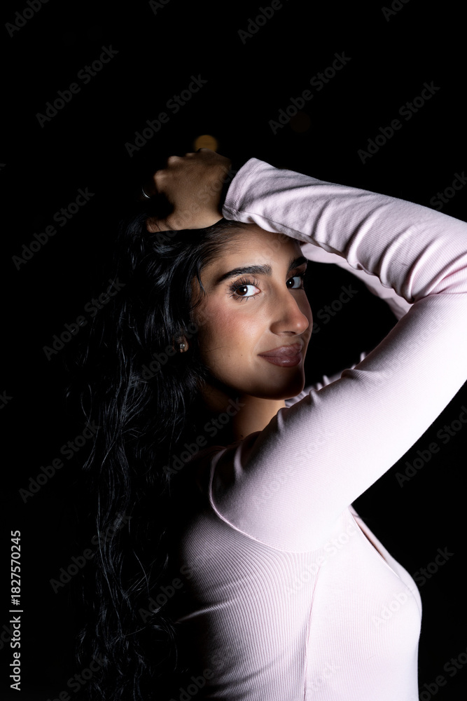 Naklejka premium Confident woman posing with dramatic lighting at night