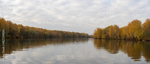 Reflection of trees in the lake. Autumn landscape. Panoramic view of the banks of the river bay	
