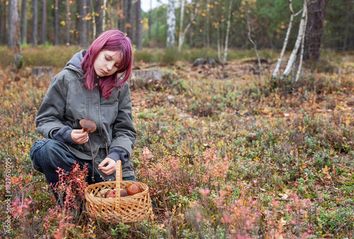 Girl foraging wild mushrooms in autumn forest