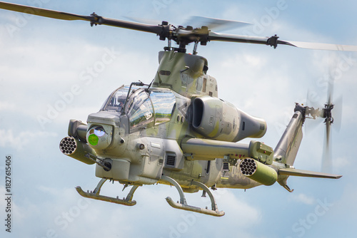 Military attack helicopter in flight over blue sky
