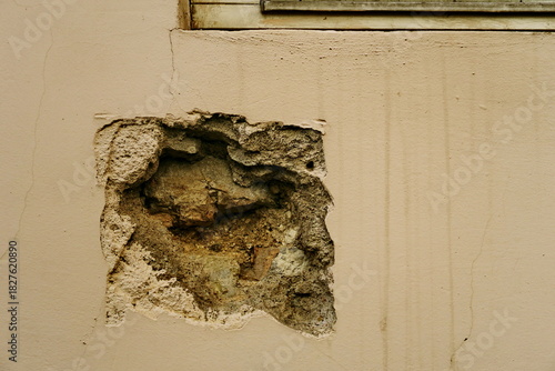 Mur troué avec mortier et pierres apparentes.