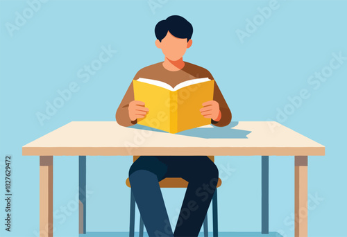 A person in a brown sweater sits at a desk, facing forward, engrossed in reading a yellow book