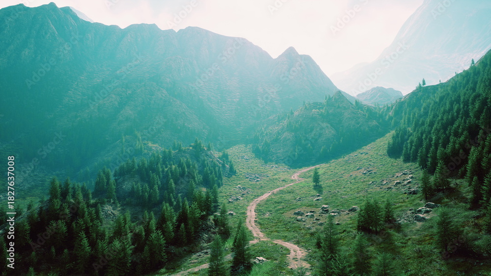 Naklejka premium A picturesque view unfolds at dawn as soft light illuminates rolling hills and vibrant greenery. A winding path invites exploration through the tranquil wilderness, rich with life.