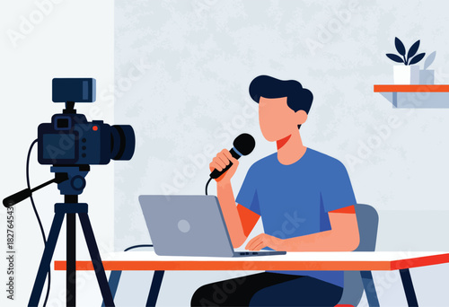 A man records a video with a camera, microphone, and laptop. A plant is in the background