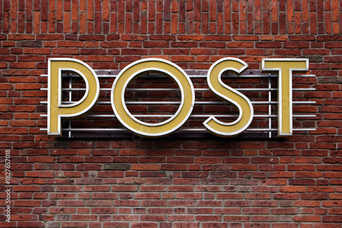 post leuchtschrift an ziegelwand