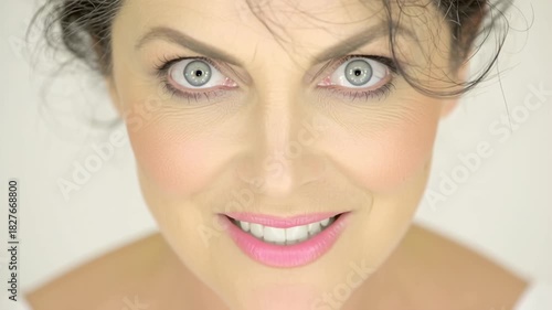 Close-up of a womans face with a wide smile and bright eyes.