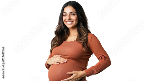Expecting mother poses happily while showing off her baby bump in cozy sweater during bright indoor setting.