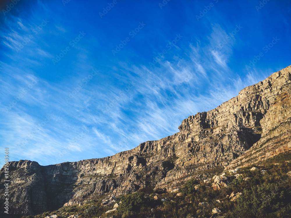 Fototapeta premium Steep Rocky Cliff Face Under Bright Blue Sky in Cape Town
