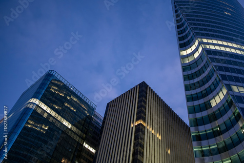 Urban architecture expressed through glass geometry and reflection accents in a low-angle corporate scene emphasizing skyscraper finance aesthetics within La Defense Paris