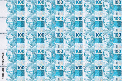 Background texture of Brazilian money bills, 100 reais notes, background for video or scenery. Concept of award or payment, fortune.