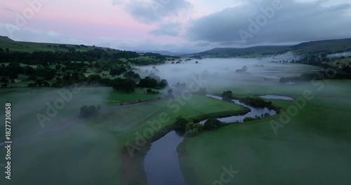 River in a misty valley at dawn