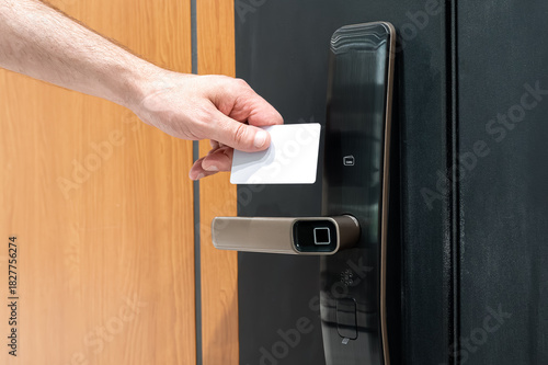 Close-up of RFID card near smart lock on door, concept of secure access in smart home