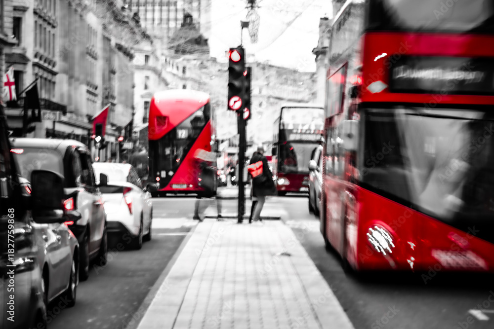 Fototapeta premium Iconic red double-decker buses in selective color on Regent Street, London – black and white
