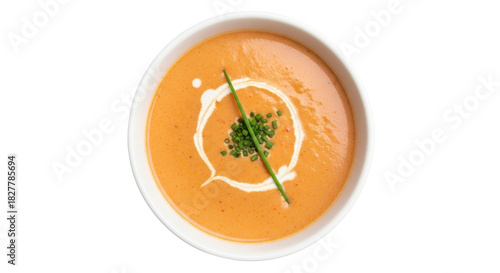 Isolated tomato soup garnished with cream and chives ready to serve, overhead view