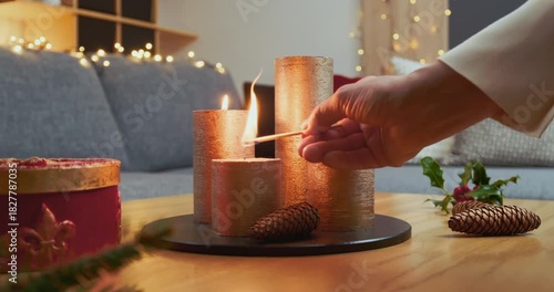 Christmas Home Decorations – A Woman is Lighting the Second Candle of a Modern Advent Arrangement