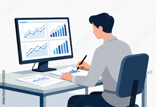 A person in a shirt sits at a desk with a monitor displaying charts and graphs, reviewing documents, and writing