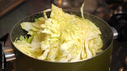 Wallpaper Mural Il cuoco mette la verza tagliata nella pentola per la cottura Torontodigital.ca