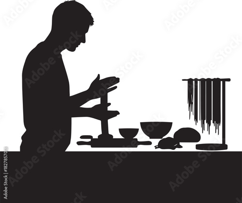 Silhouette of a craftsman diligently working on a piece with tools and materials laid out