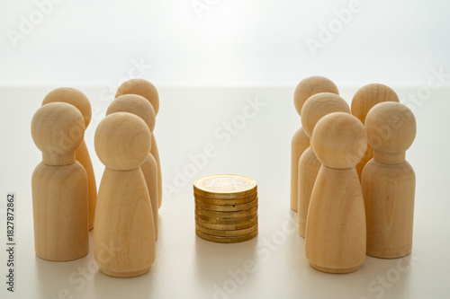 Two groups, depicted with wooden pawns, strategically analyze the distribution and impact of economic resources.